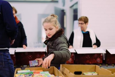 Inpakavond Kerstpakkettenactie 2018 - Meisje reikt boodschappen aan