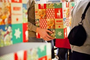 Vrijwilliger tilt een kerstpakket tijdens de inpakavond van de Kerstpakkettenactie Zwolle